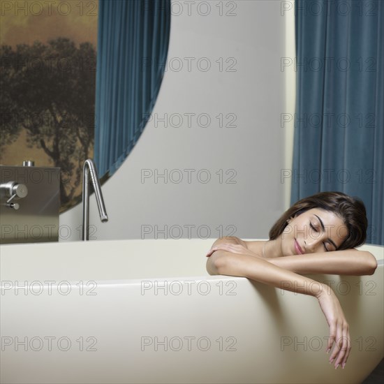 Indian woman in bathtub with eyes closed