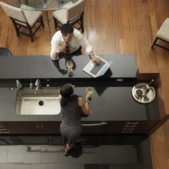 Asian couple looking at laptop in kitchen