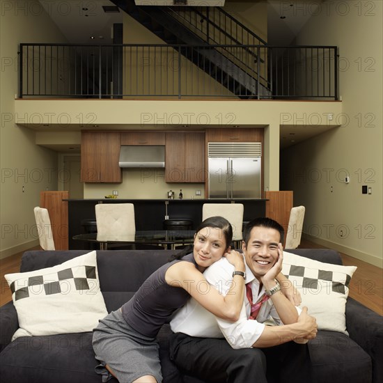Asian couple hugging on sofa