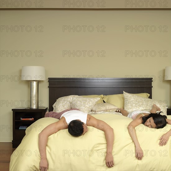 Asian couple laying on bed