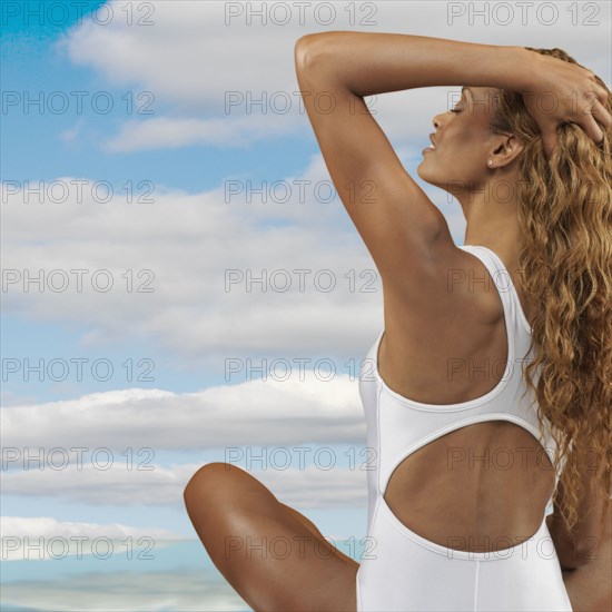 African woman wearing bathing suit with hand in hair