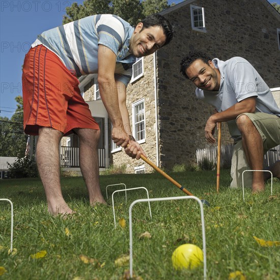 Mixed race men playing croquet