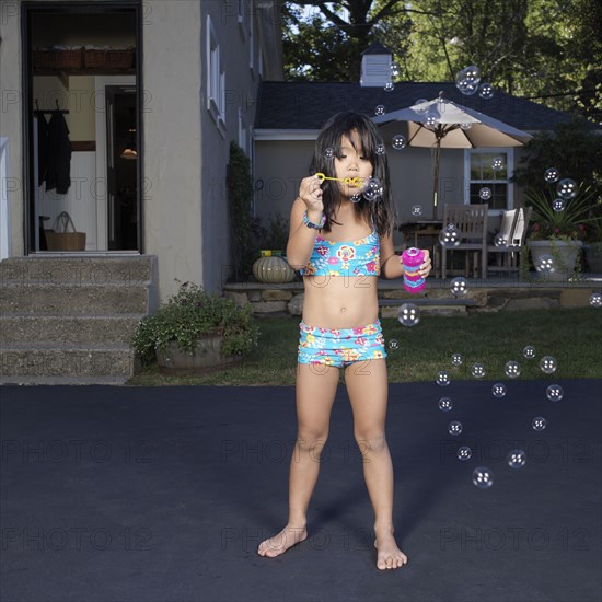 Korean girl in bikini blowing bubbles