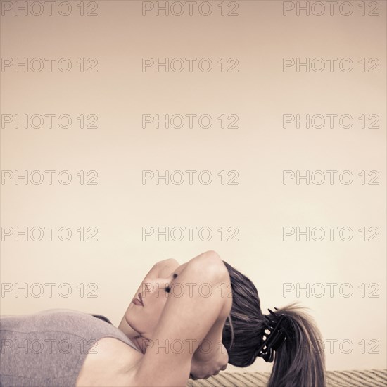 Woman doing sit-ups indoors