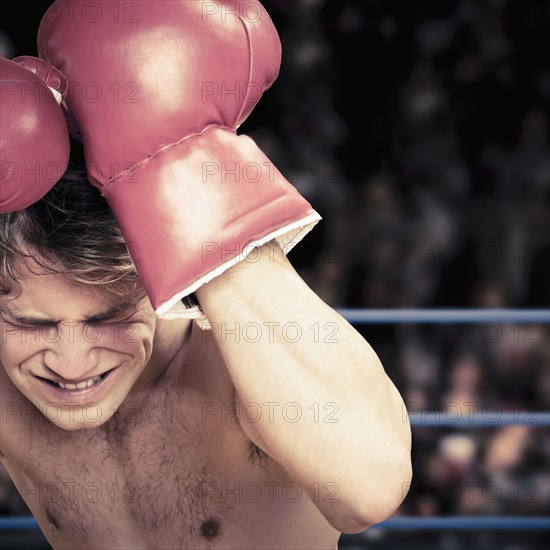 Caucasian boxer covering his head