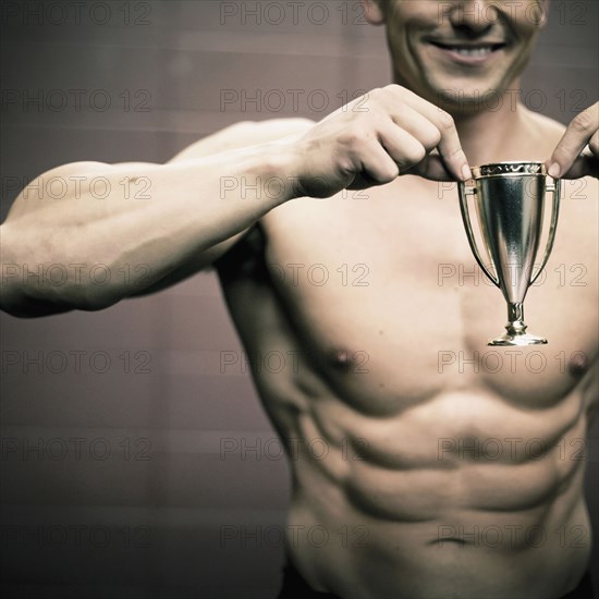 Caucasian man holding small trophy