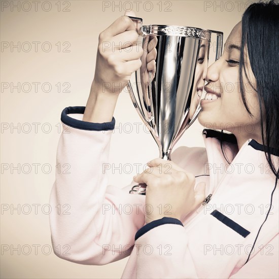 Mixed race woman holding trophy