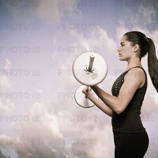 Woman using lifting weights outdoors