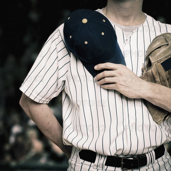 Caucasian baseball player holding hat over heart