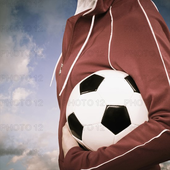 Mixed race woman carrying soccer ball