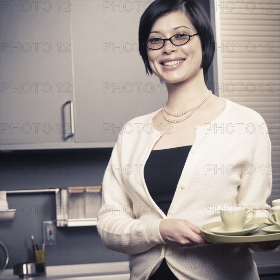 Mixed race woman smiling in kitchen