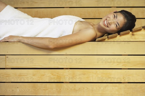 Asian woman relaxing in sauna