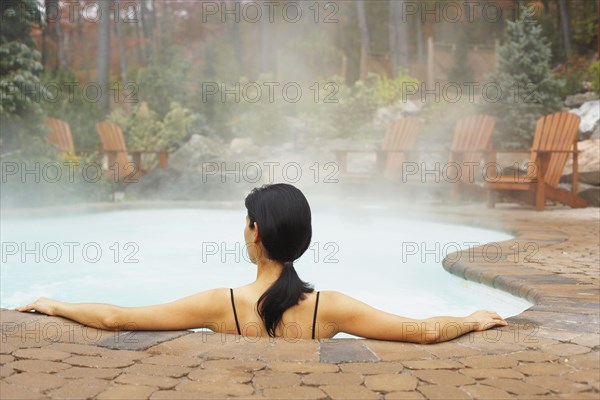 Rear view of woman sitting in hot tub