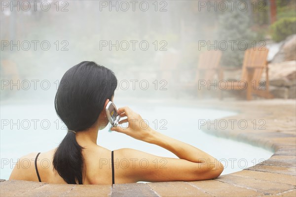 Woman talking on cell phone in hot tub