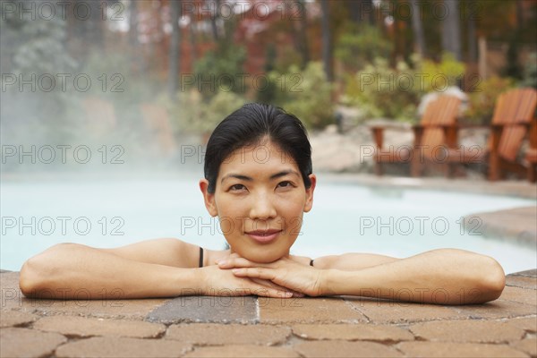 Asian woman sitting in hot tub