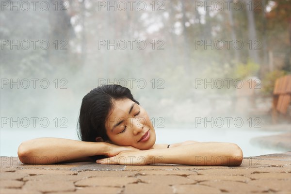 Asian woman sitting in hot tub