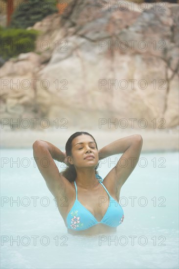 African woman standing in hot tub