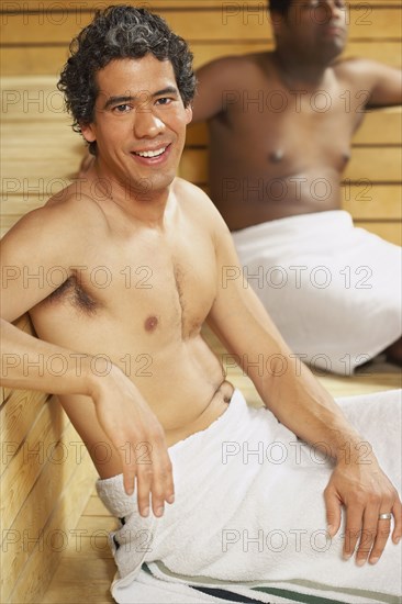 Two multi-ethnic men relaxing in sauna