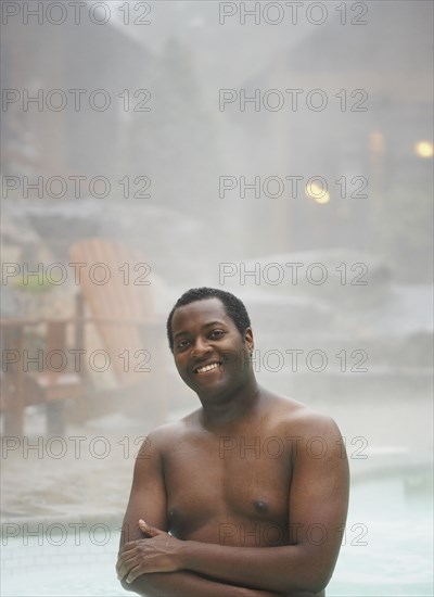 African man standing in hot tub