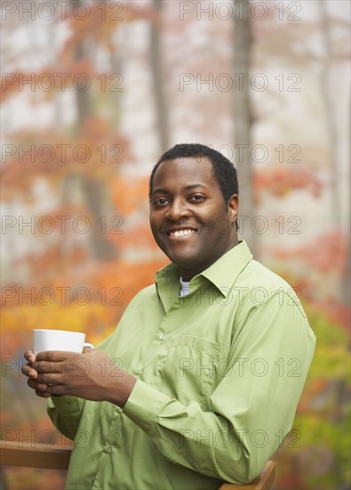 African man holding cup of coffee