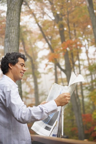 Man reading newspaper outdoors