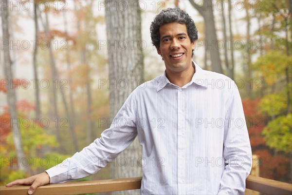 Man standing on deck in woods