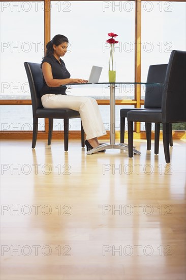 Indian woman typing on laptop