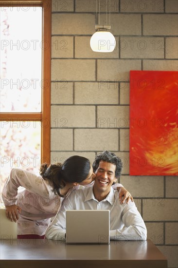 Woman kissing husband's cheek