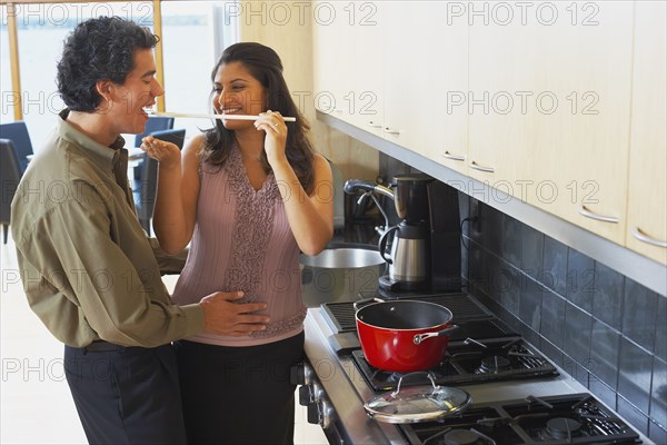 Woman feeding husband in kitchen