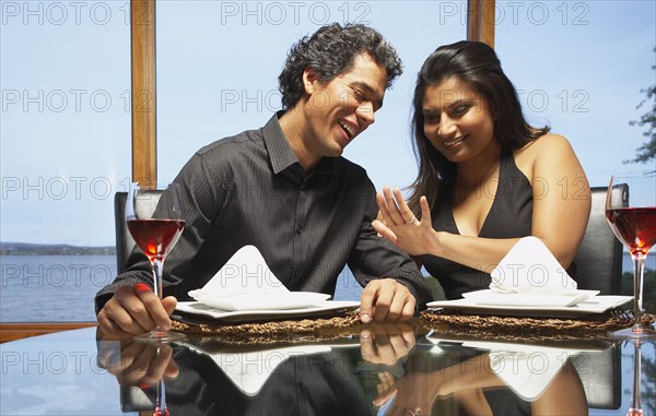 Couple smiling at engagement ring