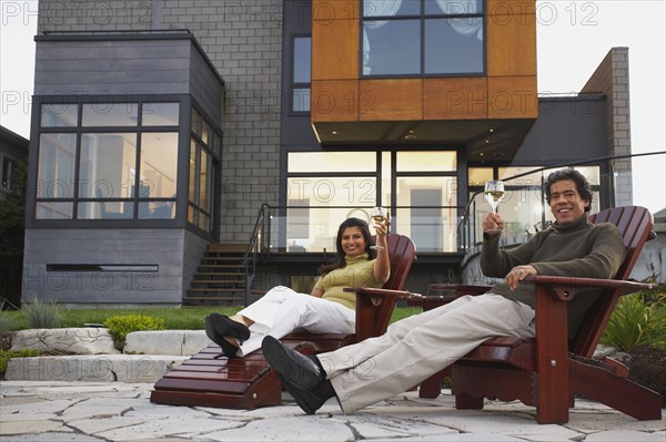 Couple toasting in deck chairs