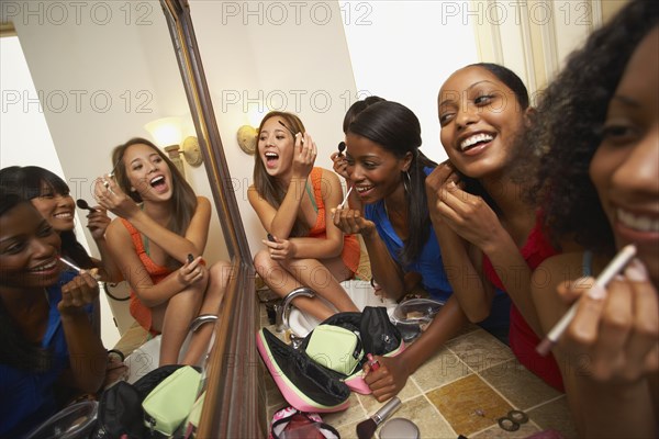 Multi-ethnic group of friends applying makeup