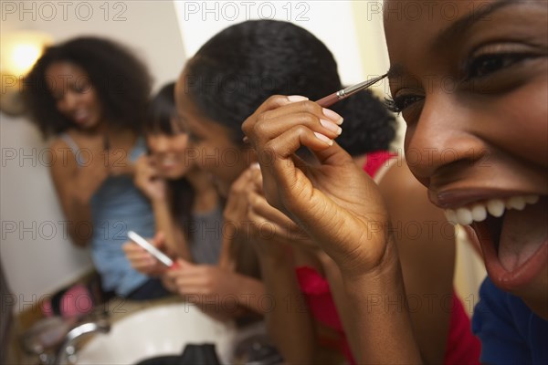 Multi-ethnic group of friends applying makeup