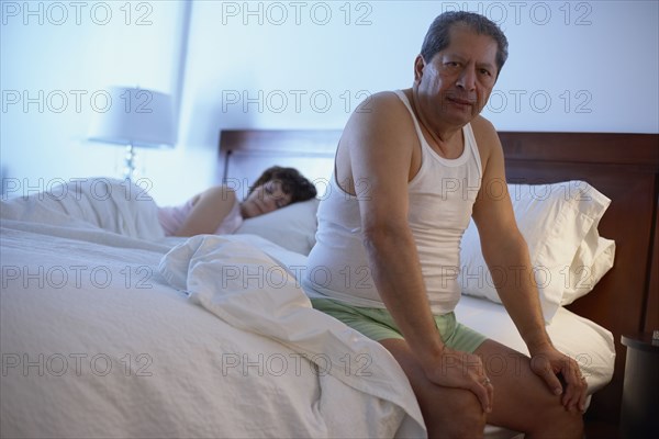 Man in bedroom waking up in the morning