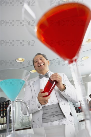 Hispanic host mixing martini cocktails at party