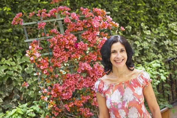 Confident Middle Eastern woman standing in garden