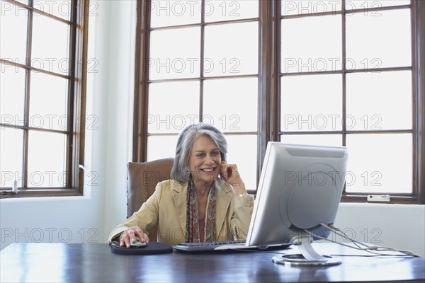 Confident businesswoman working on computer at desk