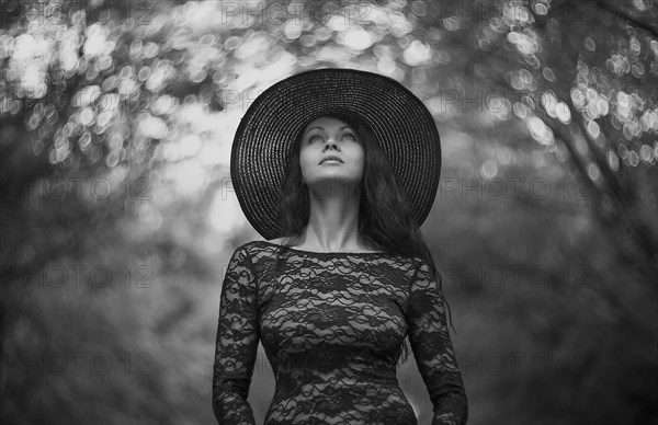 Caucasian woman wearing sun hat under trees