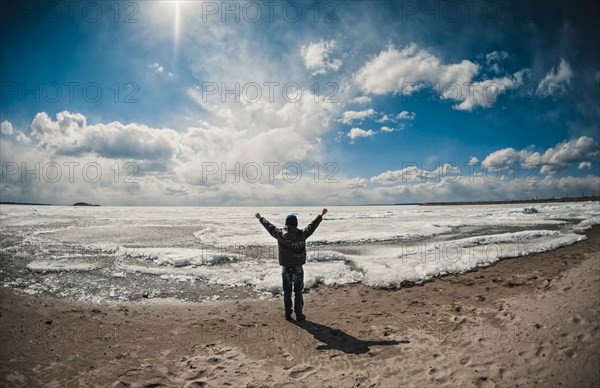 Caucasian boy cheering on ocean beach