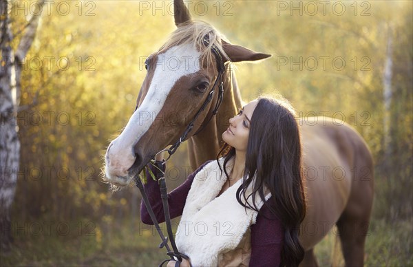 Caucasian woman petting horse