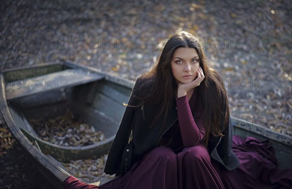 Caucasian woman sitting on boat on land