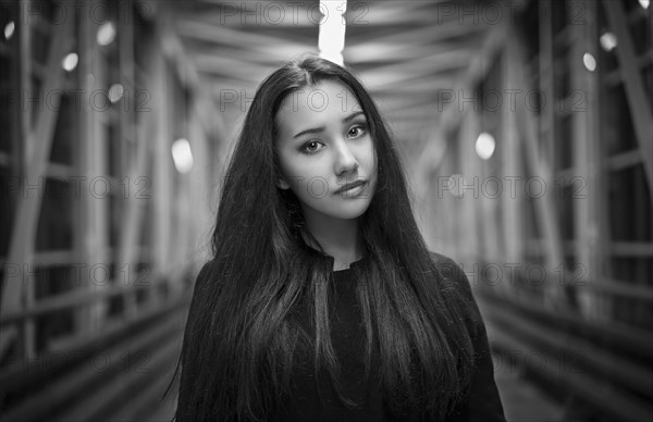 Portrait of serious Mixed Race teenage girl on footbridge