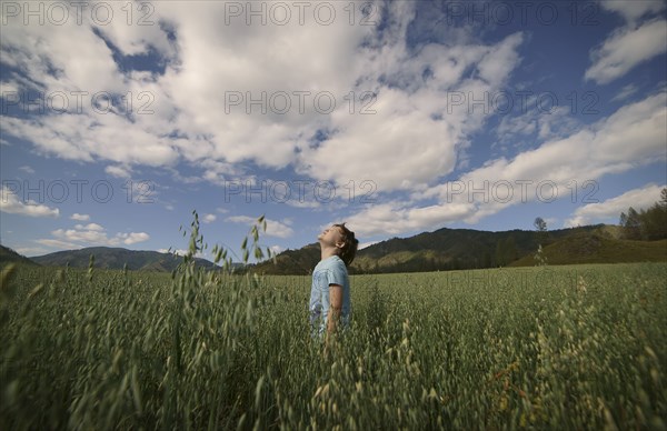 Caucasian boy standing in field looking up