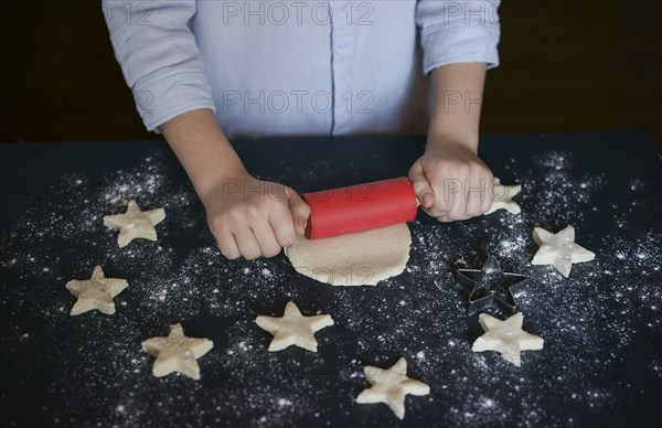 Caucasian boy rolling cookie dough