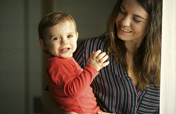 Caucasian mother holding smiling baby son