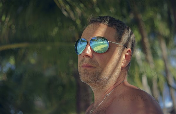 Serious man wearing sunglasses in summer