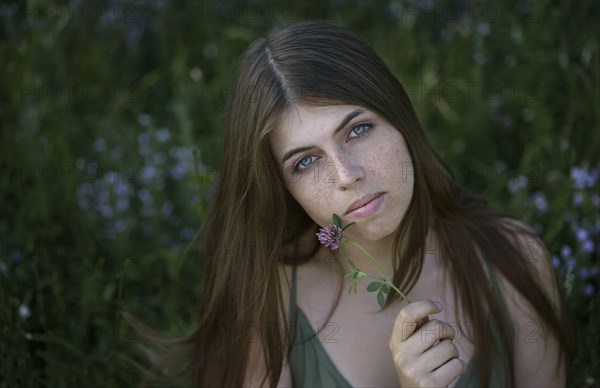 Portrait of pensive Caucasian woman holding flower