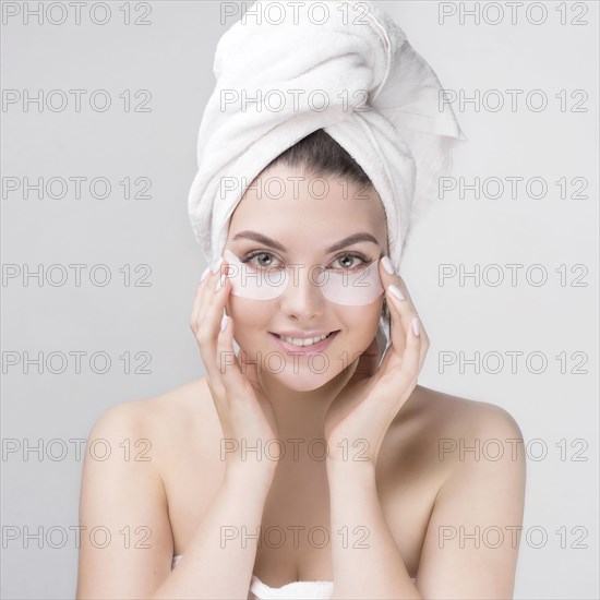 Caucasian woman applying makeup to cheeks