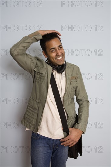 Mixed race man wearing headphones and bag