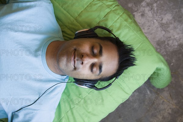 Mixed race man listening to headphones